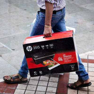 A man carries a boxed Hewlett-Packard Co. 2515 printer in Nehru Place IT Market, a hub for the sale of electronic goods and computer accessories, in downtown New Delhi, India on Wednesday Aug. 7, 2013. India's consumer price index (CPI) figures for July are scheduled to be released on August 12. 