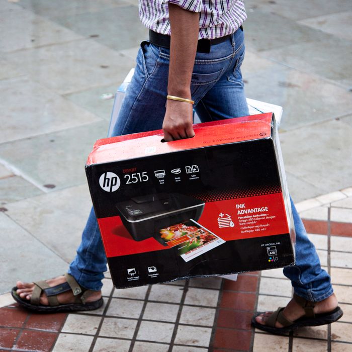 A man carries a boxed Hewlett-Packard Co. 2515 printer in Nehru Place IT Market, a hub for the sale of electronic goods and computer accessories, in downtown New Delhi, India on Wednesday Aug. 7, 2013. India's consumer price index (CPI) figures for July are scheduled to be released on August 12.