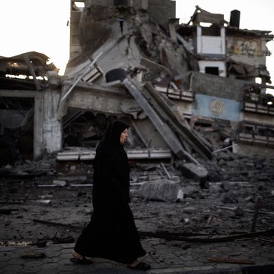 A Palestinian woman walks past a house destroyed during an Israeli airstrike, on November 20, 2012. Israeli leaders discussed an Egyptian plan for a truce with Gaza's ruling Hamas, reports said, before a mission by the UN chief to Jerusalem and as the toll from Israeli raids on Gaza rose over 100.