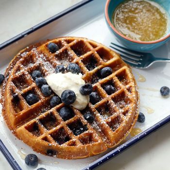Blueberry-corn waffle with warm honey butter and housemade clabber cream.