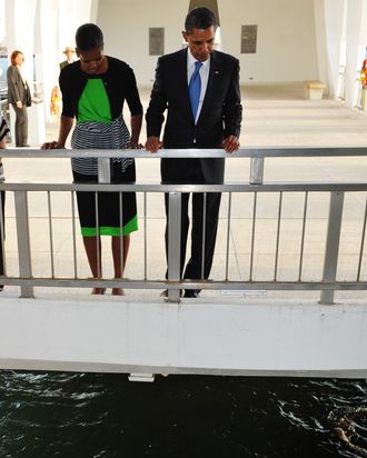 US President Barack Obama and First Lady Michelle Obama pay their respects at the USS Arizona Memorial at Pearl Harbor December 29, 2011 in Honolulu, Hawaii. AFP PHOTO/Mandel NGAN (Photo credit should read MANDEL NGAN/AFP/Getty Images)