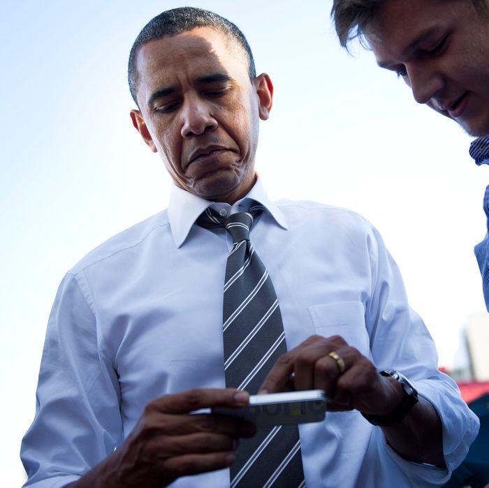 US President Barack Obama looks at a persons iPhone outside The Sink Restaurant and Bar April 24, 2012 in Boulder, Colorado.
