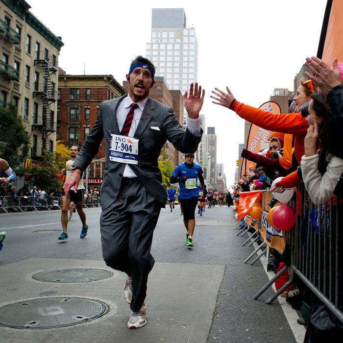 A man in a suit runs up First Avenue November 3, 2013 during the running of the New York City Marathon in New York. 