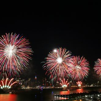 The New York City skyline is seen in the distance as fireworks explode over the Hudson River