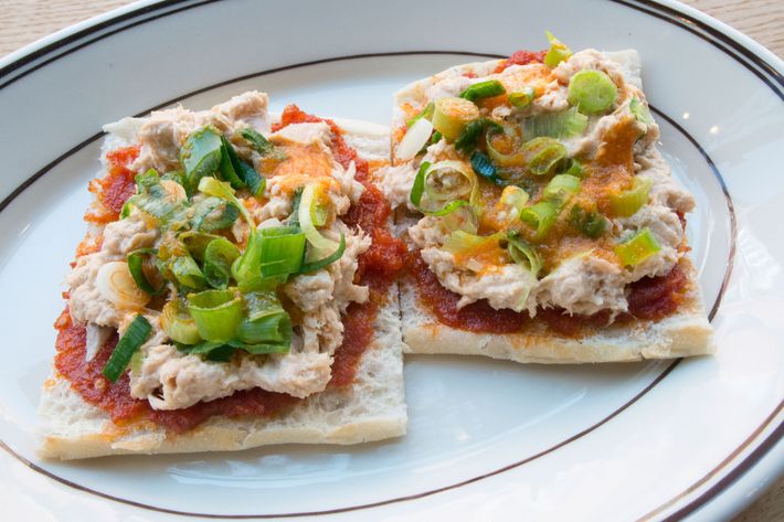 Crostino topped with tuna spread, tomato pesto, scallions, and chile oil.