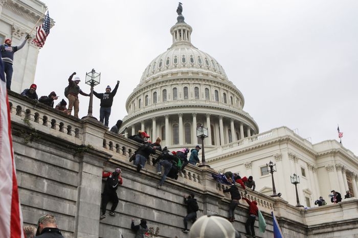 Supporters of President Donald Trump climb on the walls at the U.S. Capitol during a protest against the certification of the 2020 U.S. presidential election results by the U.S. Congress, in Washington, D.C.