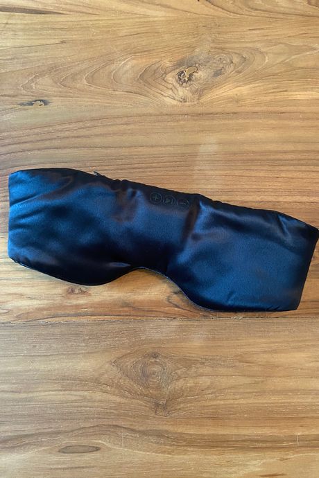 A black silk eye mask on a table.