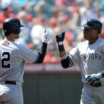 ANAHEIM, CA - SEPTEMBER 11: Robinson Cano #24 of the New York Yankees celebrates his solo homerun with Eric Chavez #12 to trail 3-2 to the Los Angeles Angels of Anaheim during the fourth inning at Angel Stadium of Anaheim on September 11, 2011 in Anaheim, California. (Photo by Harry How/Getty Images)