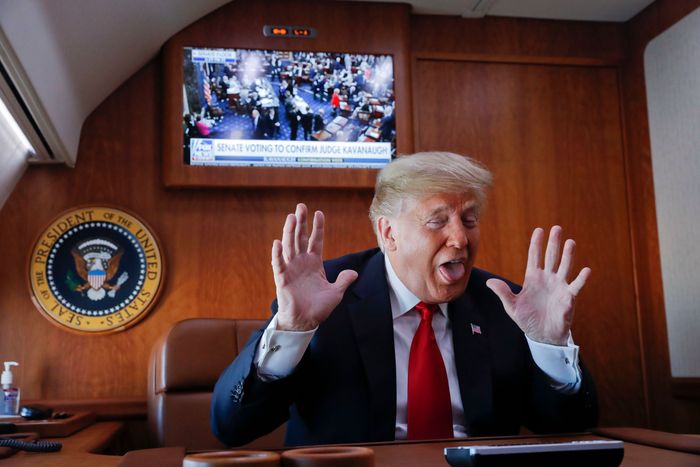 President Donald Trump gestures while watching a second monitor in front of him of the live broadcast of the U.S. Senate confirmation vote of Supreme Court nominee Brett Kavanaugh on October 6, 2018, while aboard Air Force One.