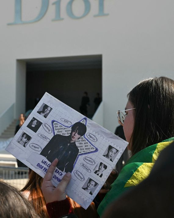 A fan waits for members of K-pop boy band BTS outside of the Dior show.