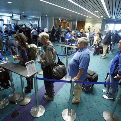 In this April 30, 2012, photo shows travelers passing through the security check point at Portland International Airport, in Portland, Ore. Airport security procedures, with their intrusive pat downs and body scans, don’t need to be toughened despite the discovery of a new al-Qaida airline bomb plot using more sophisticated technology than an earlier attempt, congressional and security officials said Tuesday. (AP Photo/Rick Bowmer)