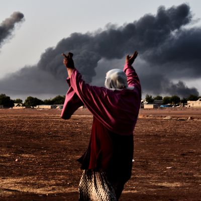 A woman reacts as smoke rises from the the Syrian town of Ain al-Arab, known as Kobane by the Kurds, after a strike from the US-led coalition as it seen from the Turkish - Syrian border in the southeastern village of Mursitpinar, Sanliurfa province, on October 13, 2014.