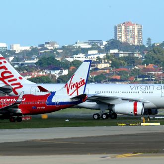 Virgin Australia's Airbus A330-200 (R) taxis past a Virgin Blue Boeing 737-800 (R) after landing at Sydney International Airport on May 4, 2011. Domestic carrier Virgin Blue and its international offshoots, Pacific Blue and V Australia, will all be known as Virgin Australia, with negotiations underway to bring Polynesia Blue under the same umbrella.