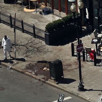 Investigators stand at the scene of twin bombings at the Boston Marathon on April 17, 2013 in Boston, Massachusetts. The explosions, which occurred near the finish line of the 116-year-old Boston race on April 15, resulted in the deaths of three people with more than 170 others injured. Security has been heightened across the nation as the search continues for the person or people behind the bombings. 