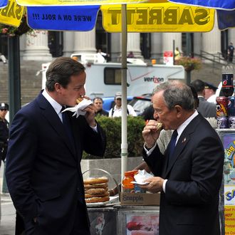 New York City Mayor Michael Bloomberg and British Prime Minister David Cameron (L) share a hot dog outside of Penn Station on July 21, 2010. Cameron arrived in the city by train for meetings.