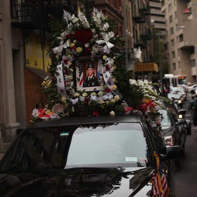 NEW YORK, NY - OCTOBER 13: A portrait of U.S. Army Pvt. Danny Chen is viewed on a car in his funeral procession in Chinatown on October 13, 2011 in New York City. Pvt. Chen who had been in Afghanistan for two months, was found dead with a gunshot wound below his chin on Oct. 3. While preliminary signs suggest Pvt. Chen killed himself, the Army has told the soldiers parents that he was subjected to taunting and violence by some of the soldiers with whom he served with. (Photo by Spencer Platt/Getty Images)