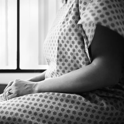 Midsection of female patient waiting in hospital exam room