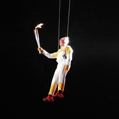 South Korean athlete Ryu Seung-min carries the Olympic torch as he hangs from a wire during the Olympic Torch Relay.