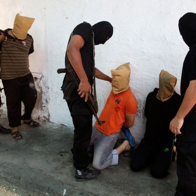 Hamas militants grab Palestinians suspected of collaborating with Israel, before executing them in Gaza City August 22, 2014. 