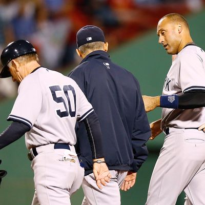 Derek Jeter #2 of the New York Yankees walks off of the field with first base coach Mick Kelleher #50 and manager Joe Girardi #28 after injuring himself on a close play at first base against the Boston Red Sox during the game on September 12, 2012 at Fenway Park in Boston, Massachusetts.