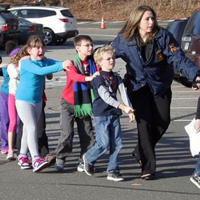 In this photo provided by the Newtown Bee, Connecticut State Police lead children from the Sandy Hook Elementary School in Newtown, Conn., following a reported shooting there Friday, Dec. 14, 2012. (AP Photo/Newtown Bee, Shannon Hicks) MANDATORY CREDIT