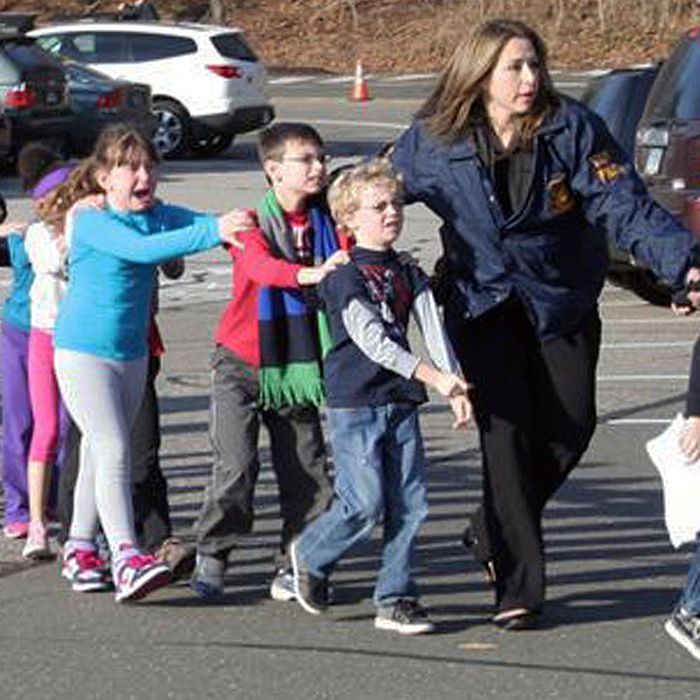 In this photo provided by the Newtown Bee, Connecticut State Police lead children from the Sandy Hook Elementary School in Newtown, Conn., following a reported shooting there Friday, Dec. 14, 2012. (AP Photo/Newtown Bee, Shannon Hicks) MANDATORY CREDIT