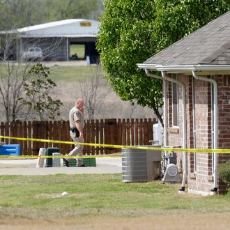 A Kaufman County Sheriff's deputy walks near the taped-off property of Kaufman County District Attorney Mike McLelland, near Forney, Texas, on Sunday, March 31, 2013. On Saturday, McLelland and his wife, Cynthia, were murdered in their home. (AP Photo/Mike Fuentes)