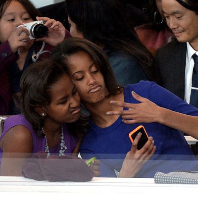 Sasha (L) and Malia Obama, daughters of US President Barack Obama, take a photo of themselves during the Presidential Inaugural Parade on January 21, 2013 in Washington, DC.