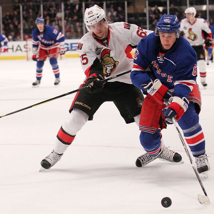 Carl Hagelin #62 of the New York Rangers skates with the puck against Erik Karlsson #65 of the Ottawa Senators