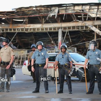 FERGUSON, MO - AUGUST 11: Police guard a Quick Trip gas station that was burned yesterday when protests over the killing of 18-year-old Michael Brown turned to riots and looting on August 11, 2014 in Ferguson, Missouri. Police responded with tear gas and rubber bullets as residents and their supporters protested the shooting by police of an unarmed black teenager named Michael Brown who was killed Saturday in this suburban St. Louis community. Yesterday 32 arrests were made after protests turned into rioting and looting in Ferguson. (Photo by Scott Olson/Getty Images)