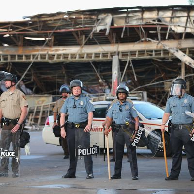 FERGUSON, MO - AUGUST 11: Police guard a Quick Trip gas station that was burned yesterday when protests over the killing of 18-year-old Michael Brown turned to riots and looting on August 11, 2014 in Ferguson, Missouri. Police responded with tear gas and rubber bullets as residents and their supporters protested the shooting by police of an unarmed black teenager named Michael Brown who was killed Saturday in this suburban St. Louis community. Yesterday 32 arrests were made after protests turned into rioting and looting in Ferguson. (Photo by Scott Olson/Getty Images)