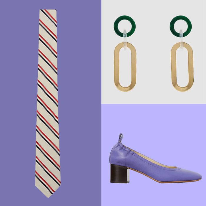 Five items for sale arranged on individual purple backgrounds. 1) A black leather wallet with a large metallic gold Jaquemus logo. 2) A white and navy striped shirt with a half length button on a model. 3) A white tie with navy and red diagonal stripes. 4) A pair of statement earrings consisting of a dark emerald green circle attached to a gold oval by a clear connector, and 5) A block heeled purple shoe with an elastic trim at the back The Strategist - 48 Things on Sale You’ll Actually Want to Buy: From Sunday Riley to Patagonia