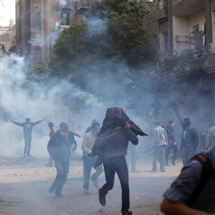 Egyptians protesters run for cover to escape tear gas fired by riot police during clashes at Cairo's landmark Tahrir Square on November 20, 2011. Several hundred Egyptians occupied Cairo's Tahrir Square with sporadic clashes between protesters and the police following a night of deadly violence, an AFP correspondent said. AFP PHOTO / KHALED DESOUKI (Photo credit should read KHALED DESOUKI/AFP/Getty Images)