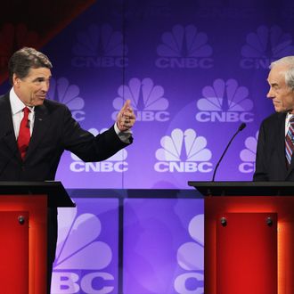 ROCHESTER, MI - NOVEMBER 09: Texas Gov. Rick Perry (L) speaks as U.S. Rep. Ron Paul (R-TX) looks on during a debate hosted by CNBC and the Michigan Republican Party at Oakland University on November 9, 2011 in Rochester, Michigan. The debate is the first meeting of the eight GOP presidential hopefuls since allegations of sexual impropriety have surfaced against front-runner Herman Cain. (Photo by Scott Olson/Getty Images)
