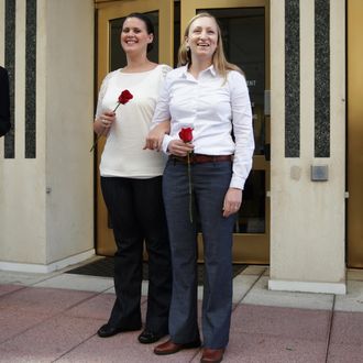 Erika Turner (R) and Jennifer Melsop (2nd R) of Centreville, Virginia, becomes the first same sex marriage in Arlington County as the couple come out from Arlington County Courthouse as Clerk of the Circuit Court of Arlington County Paul Ferguson (L) looks on October 6, 2014 in Arlington, Virginia. 