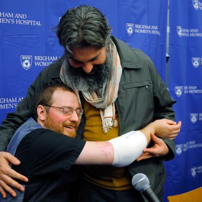 Will Lautzenheiser (L) hugs his partner Angel Gonzalez at a news conference to announce Lautzenheiser's successful double arm transplant at Brigham and Women's Hospital in Boston, Massachusetts November 25, 2014. Lautzenheiser, a 40-year-old quadruple amputee, on Tuesday thanked the Boston surgeons who performed a rare dual arm transplant on him last month and described the experience of getting the new limbs as surreal. Lautzenheiser, who lost his arms and legs to a streptococcal infection in 2011, said he has limited function in the new arms, which are encumbered by wrappings to help with healing. 