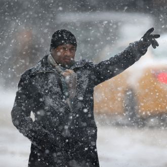NEW YORK, NY - FEBRUARY 13: A man hails a taxi in the snow on February 13, 2014 in New York City. Heavy snow and high winds made for a hard morning commute in the city. (Photo by John Moore/Getty Images)