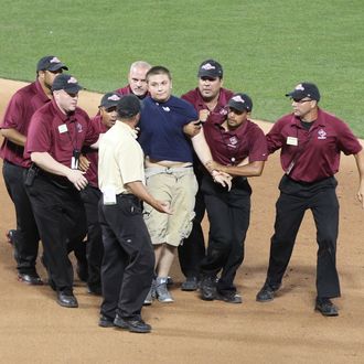 16 July 2013: A young fan runs onto the field and is captured by security and escorted away during the 2013 MLB All-Star Game between the American League and National League teams at Citi Field in Flushing, NY.