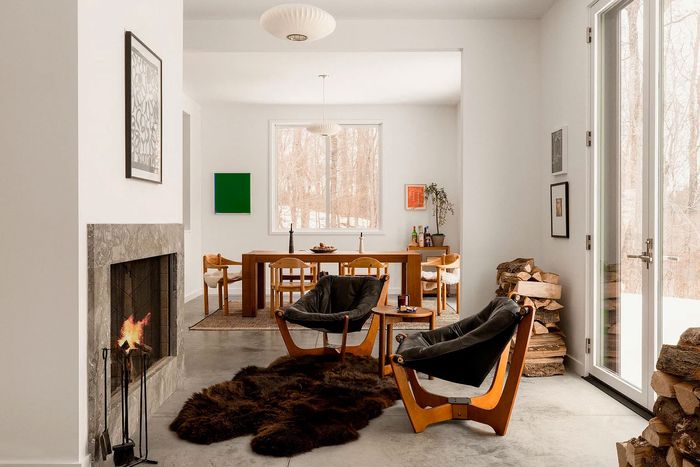 A marble fireplace with glass windows and doors looking out onto nature