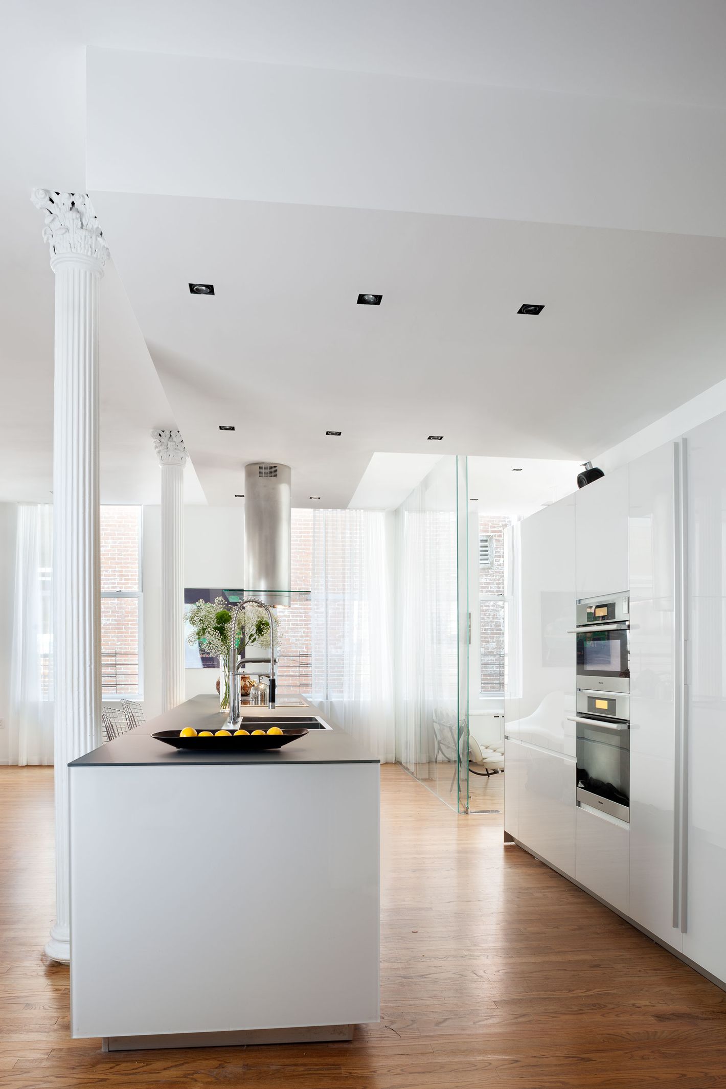 All Hail This Tribeca Family Loft With Dramatic Brick And Elegant  Industrial Details kitchen with textured ceiling, white back splash and  island - Luxe Interiors + Design