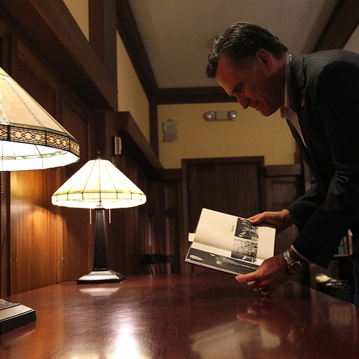 TILTON, NH - JANUARY 06: Republican presidential candidate and former Massachusetts governor Mitt Romney looks at a copy of the 1968 Tilton School yearbook that features photos of his father when he was running for president before the start of a spaghetti dinner at Tilton School on January 6, 2012 in Tilton, New Hampshire. After spending a day campaigning in South Carolina, Mitt Romney returned to New Hampshire to make a final push ahead of the New Hampshire primary. (Photo by Justin Sullivan/Getty Images)