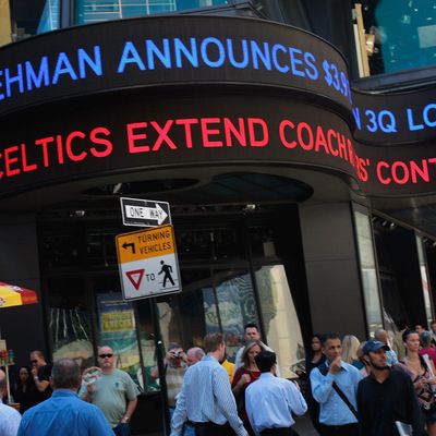 People walk under a ticker sign announcing Lehman Brothers financial losses September 10, 2008 in New York. Lehman Brothers plans to sell a majority stake in its investment management business and said a sale of the entire company was possible. 