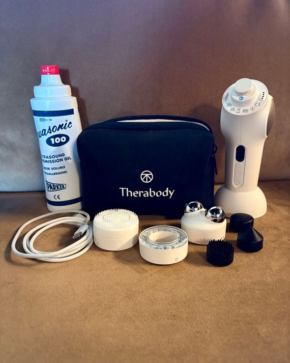 Photo of TheraFace Pro, Aquasonic ultrasound gel, assorted attachements, charging cord, and carrying case.