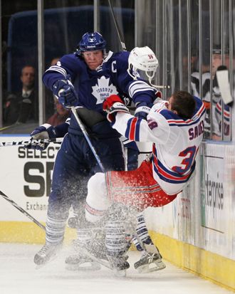 Dion Phaneuf #3 of the Toronto Maple Leafs hits Michael Sauer #38 of the New York Rangers in the third period at Madison Square Garden on December 5, 2011 in New York City. The Leafs defeated the Rangers 4-2.