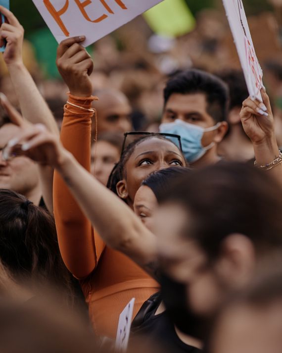 A Black woman holds up a sign in a sea of abortion-rights protesters.