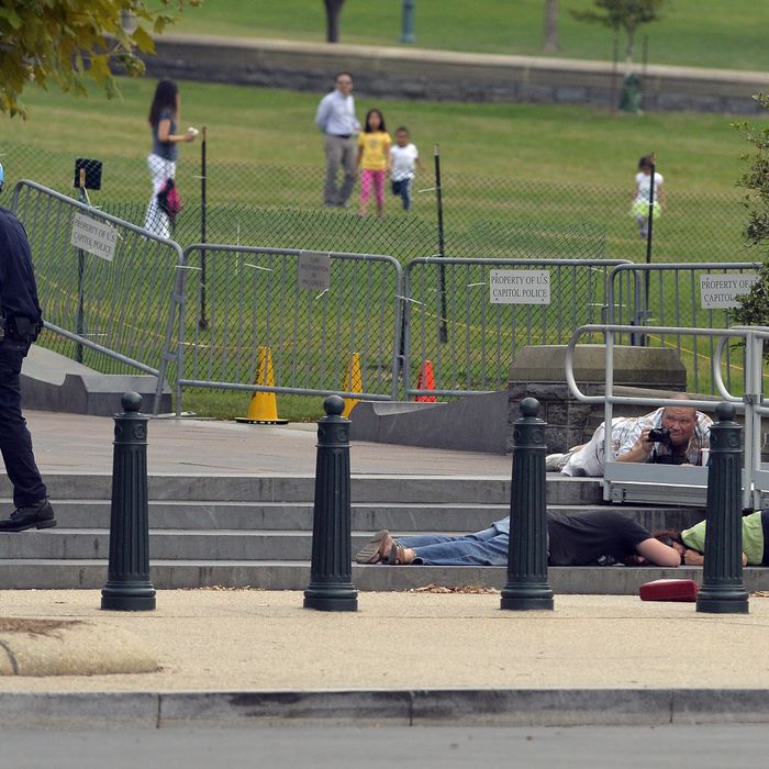 People take cover as gun shots were being heard at the US Capitol in Washington, DC, on October 3, 2013. The US Capitol was placed on security lockdown Thursday after shots were fired outside the complex, senators said.