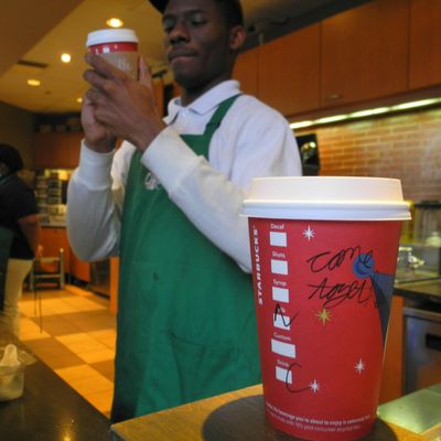 A Starbucks employee writes a message on a cup of freshly brewed coffee at a local store in Washington, DC on December 26, 2012. Starbucks stirred the political pot Wednesday by urging its baristas to write 