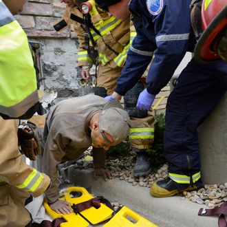 A man trapped in a wall at the rear of a Marshalls store in Longmont, Colo., crawls out of a hole and onto a backboard Tuesday, Nov. 11, 2014. Longmont Police Sgt. Matt Cage said Paul Felyk, 35, was taken to Longmont United Hospital after falling about 20 feet inside the walls and becoming trapped. The extent of his injuries was unknown Tuesday afternoon. Cage said there was evidence at the scene to suggest Felyk had been trapped in the wall as long as three days.