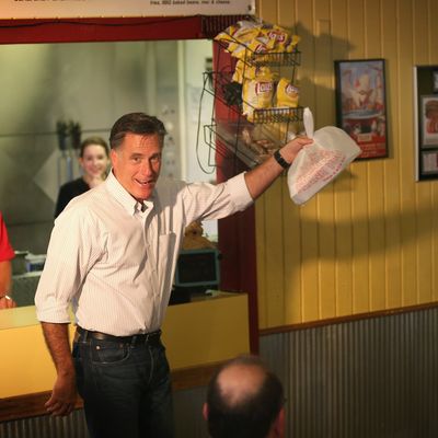 EVANSVILLE, IN - AUGUST 04: Republican presidential candidate and former Massachusetts Gov. Mitt Romney (C) grabs a bag of food before leaving a campaign event at Stepto's Bar B Q Shack on August 4, 2012 in Evansville, Indiana. Romney told supporters gathered at the restaurant that the latest jobs report was evidence that Obama’s economic policies were not working. (Photo by Scott Olson/Getty Images)