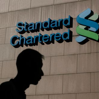 A man walks pass the Standard Chartered Bank headquarters in Hong Kong Wednesday, Oct. 13, 2010. Standard Chartered PLC said Wednesday it is asking its shareholders for nearly 3.3 billion pounds ($5.2 billion) in a rights issue to satisfy tighter international capital requirements for banking. (AP Photo/Kin Cheung)